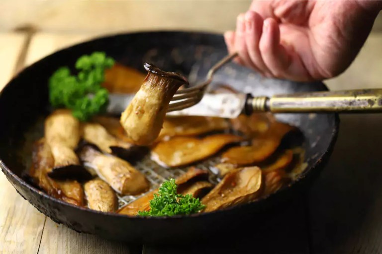 Gourmet mushroom recipes being cooked in a black pan.